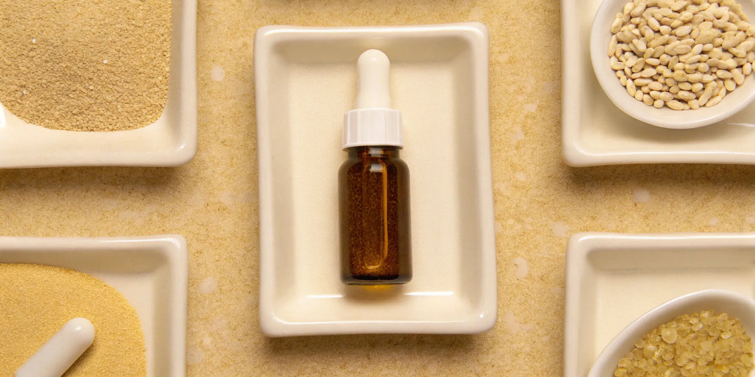 A dropper bottle of supplements for bowel regularity surrounded by natural fiber and grain ingredients.