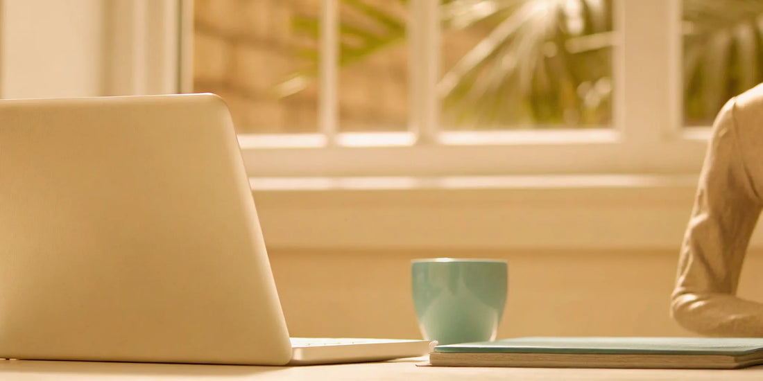 A calm and organized desk with a laptop, a result of the mood and focus benefits of postbiotics.