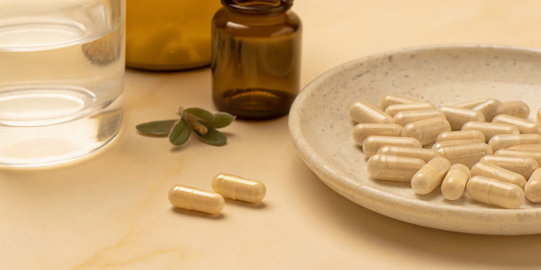 A plate of the best supplements for digestive comfort next to a glass of water.