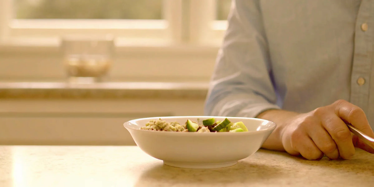Man with a bowl of food wondering why he feels bloated after every meal.