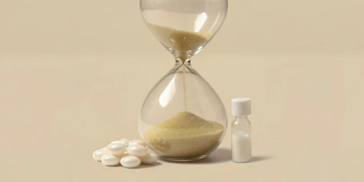 An hourglass and postbiotic capsules showing how long it takes to see digestive benefits.