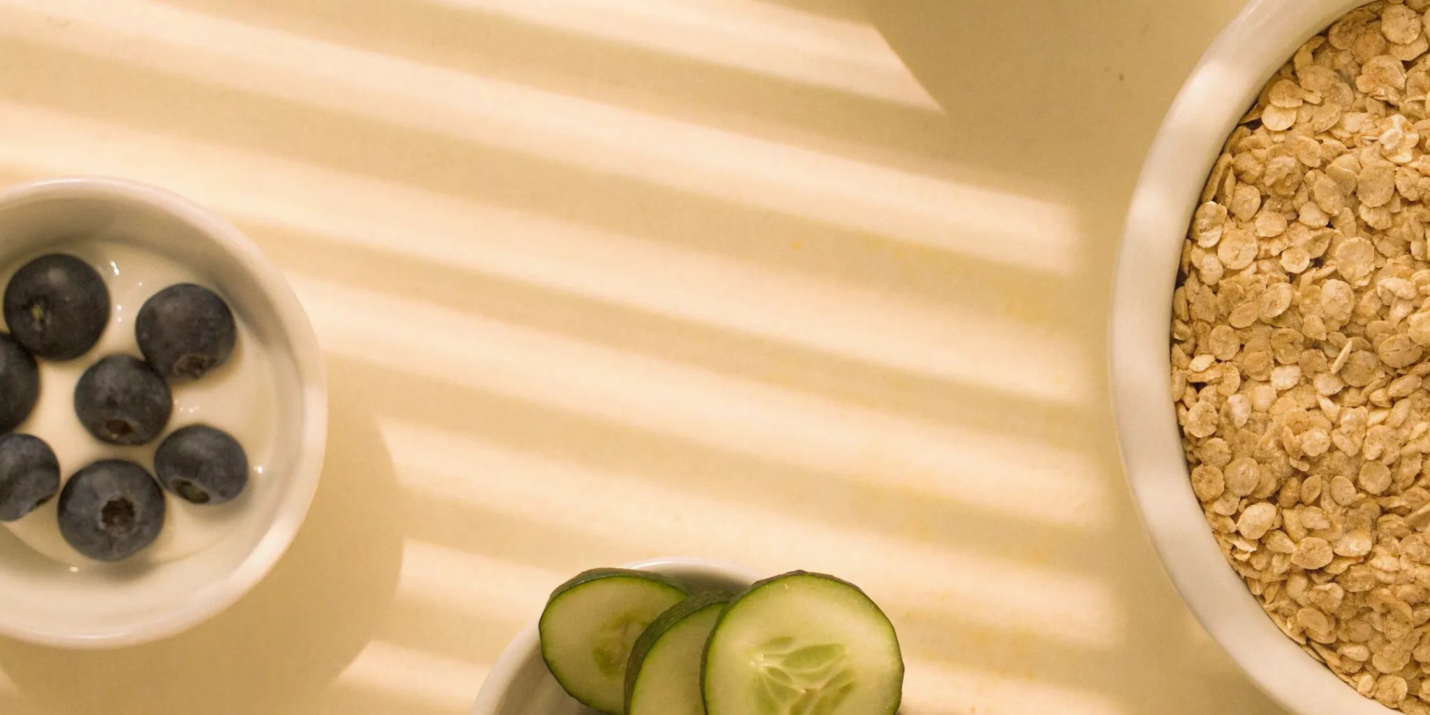 A gut health reset meal with oats, blueberries, and cucumber in bowls.