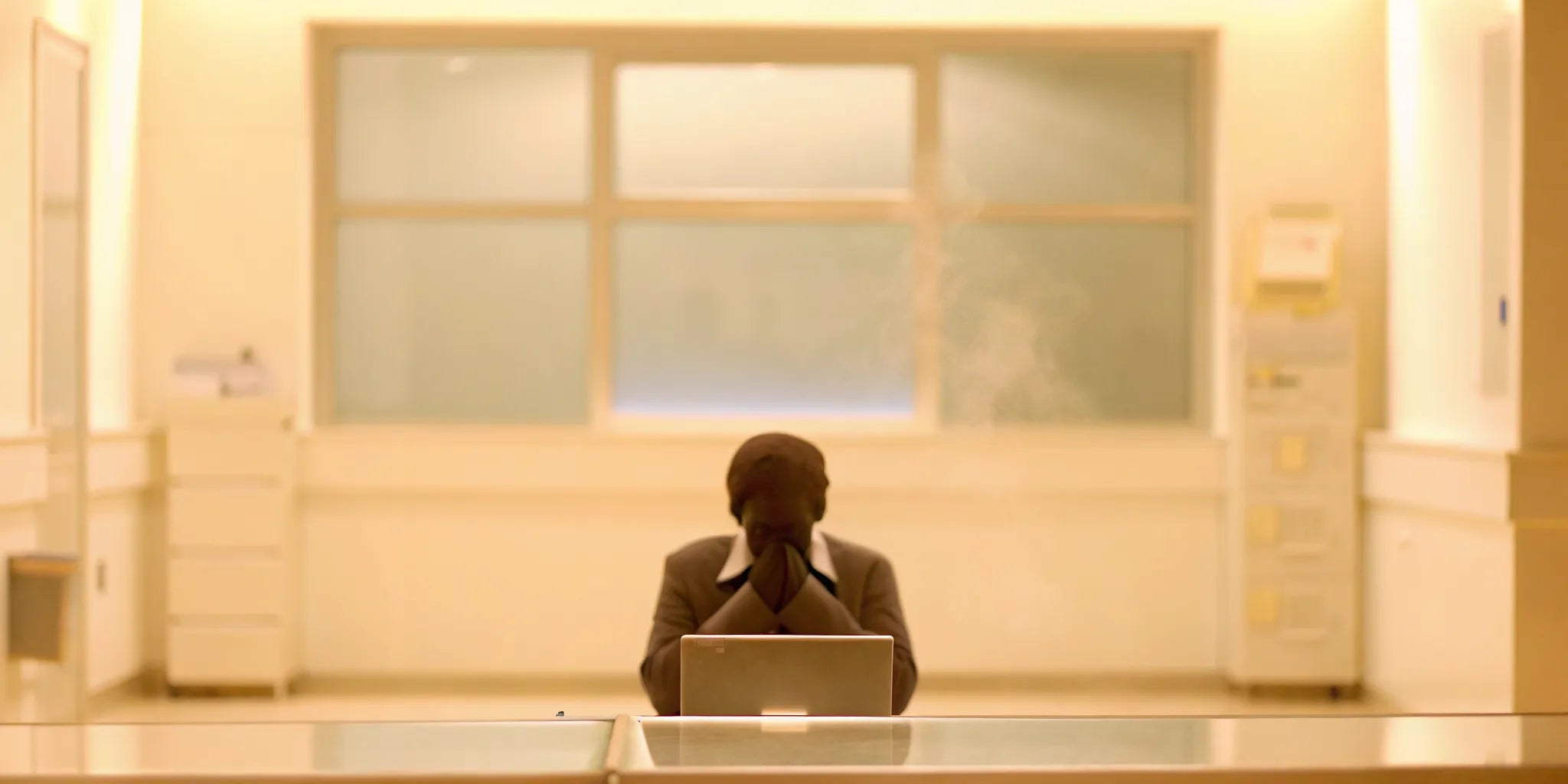 A person with their head in their hands, worried if their persistent brain fog is dangerous.