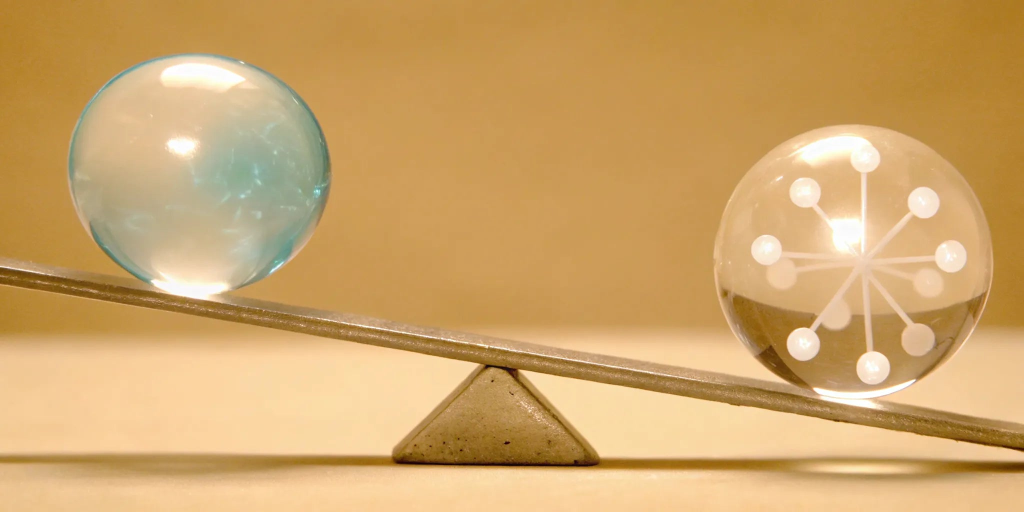 Glass spheres balanced on a seesaw for mood balance and support.