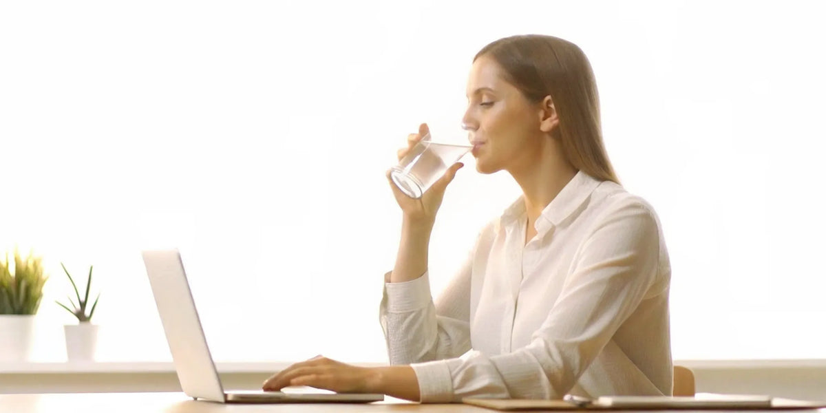 Woman in her thirties at a sunlit desk feeling focused and naturally energized