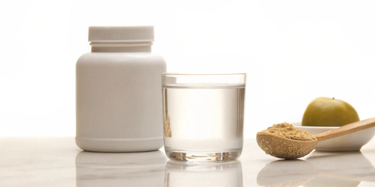 Reddit's best supplement for constipation, with a supplement bottle and glass of fiber powder.