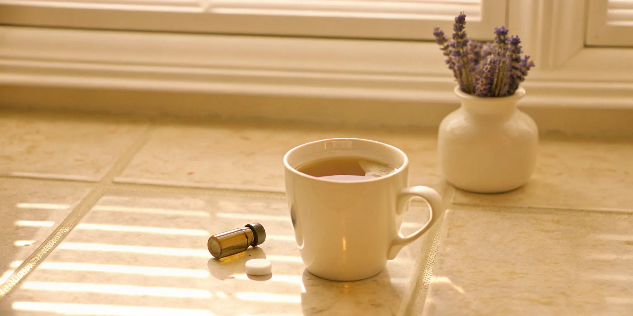 Vitamins for stress and anxiety on a sunlit counter with a cup of tea and lavender.
