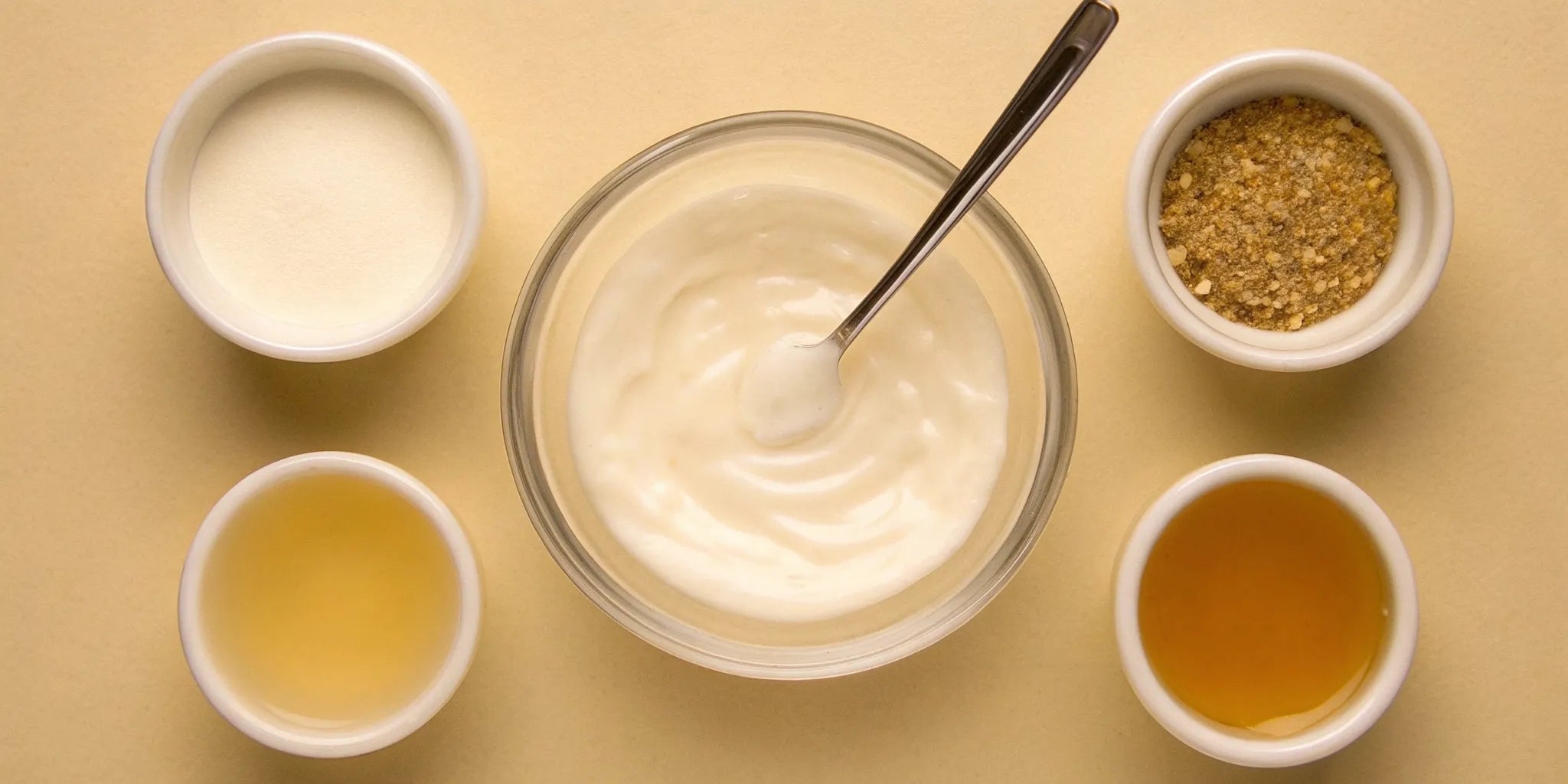 A bowl of yogurt surrounded by foods that create postbiotics for gut health.