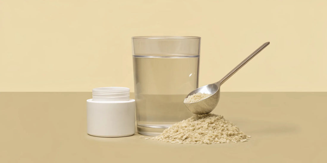 A scoop of the best supplement for regular bowel movements next to a glass of water.
