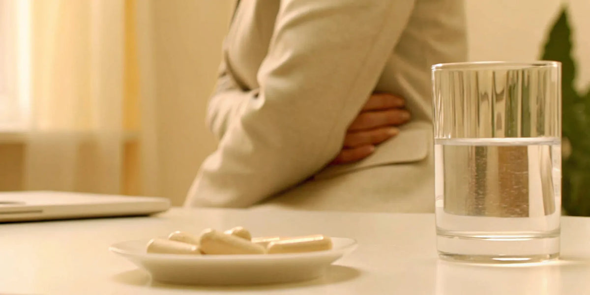 Person holding their stomach from bloating and digestive discomfort caused by probiotics.