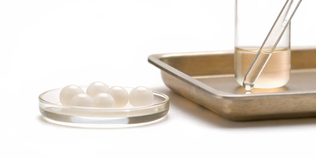 Postbiotic supplement pearls in a petri dish, a stable alternative to probiotics for gut health.