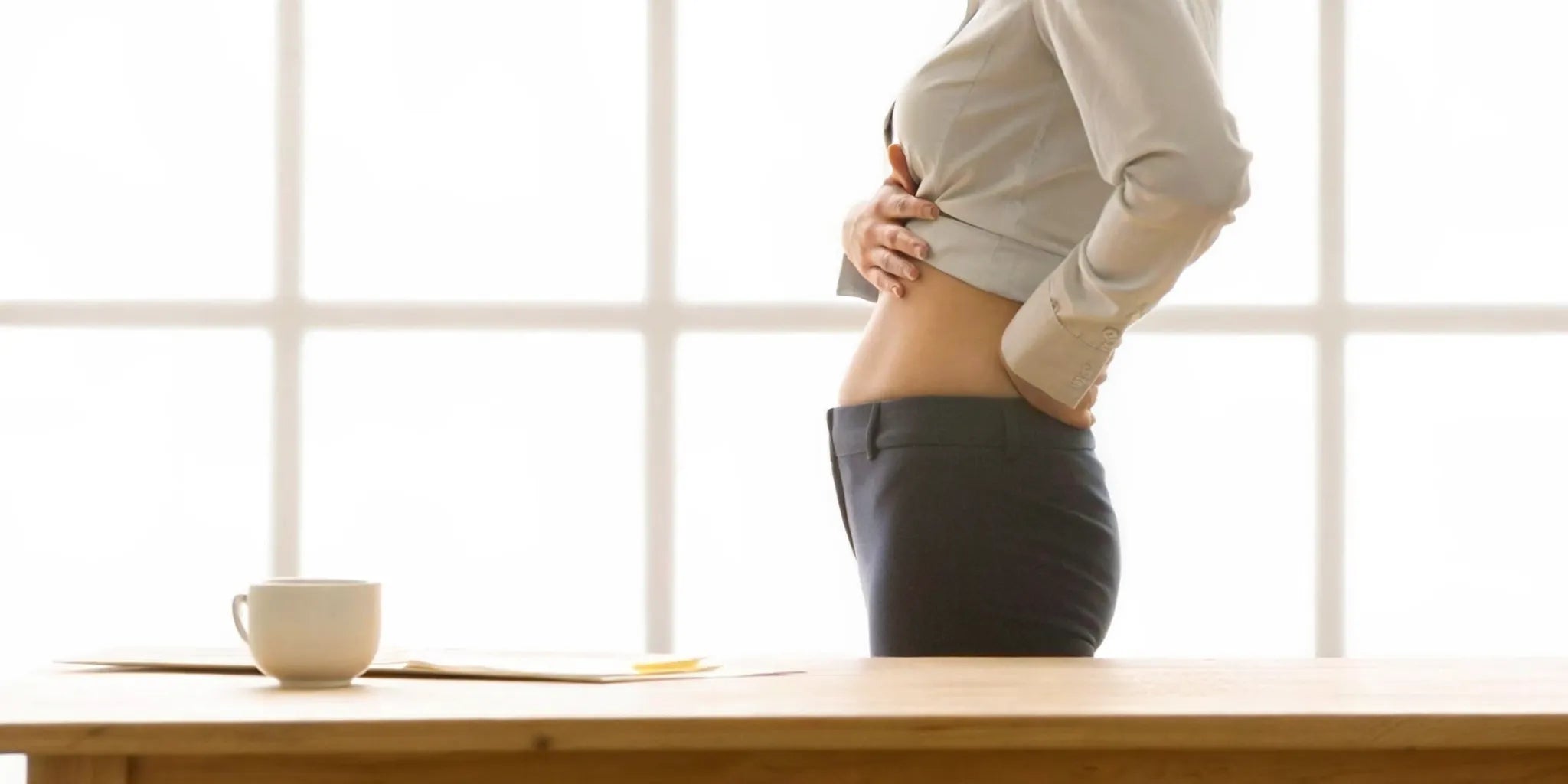 Woman holding her stomach in discomfort from a heavy feeling.
