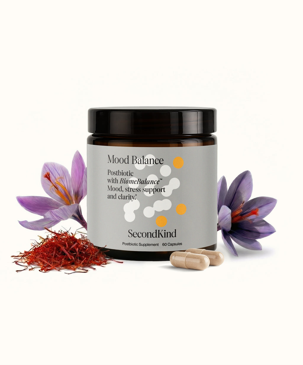 A jar labeled Mood Balance sits on a white background with capsules in front, surrounded by saffron threads and purple crocus flowers. The label highlights Mood Balance, a postbiotic supplement for mood support and stress relief.